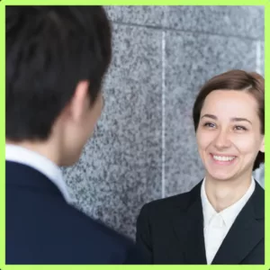 A woman smiles as she talks to a man face to face. 