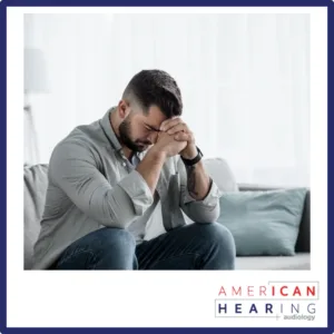 A depressed man sits on a couch. 