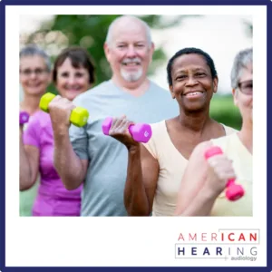 Older people lift weights outside. 