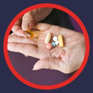 A hand holds many different pills.