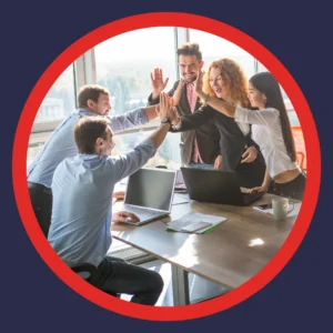 A corporate team high-fives over a conference table. 
