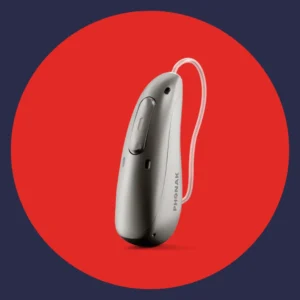 A silver Phonak Sphere Ultra hearing aid stands on a red background.