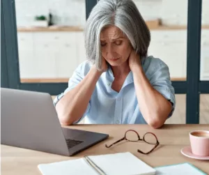 A woman looks stressed as she sits in front of her laptop.