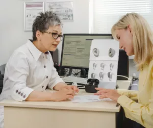 An audiologist and her patient discuss different types of hearing aids. 