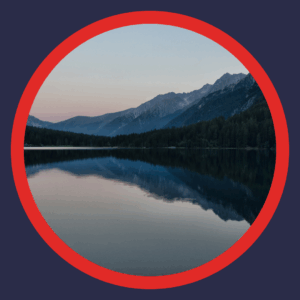 A still lake has mountains in the background. 