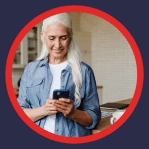 An older woman smiles at her phone.