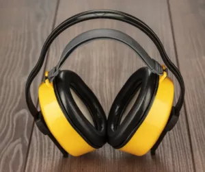 Yellow hearing safety protection headphones on a brown background. 