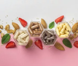 A selection of vitamins, fruits, and nuts on a table.