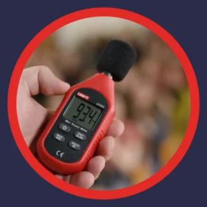 A hand holds a decibel meter. 