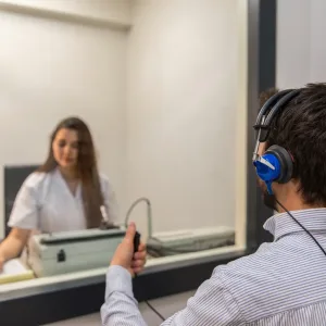 An audiologist tests a patient’s hearing at a hearing aid center.