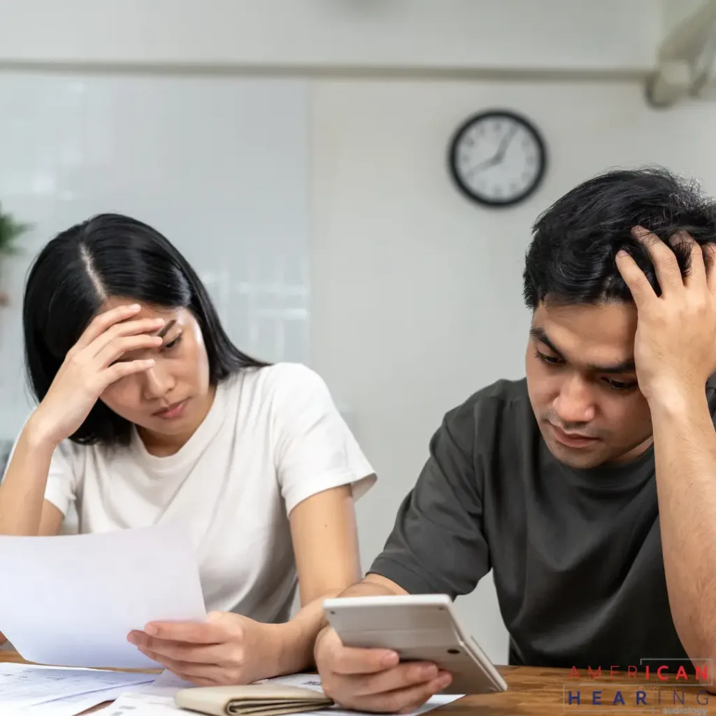 A couple looks over their insurance paperwork unhappily.