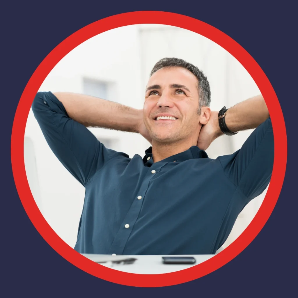 A man relaxes back with his hands behind his head.