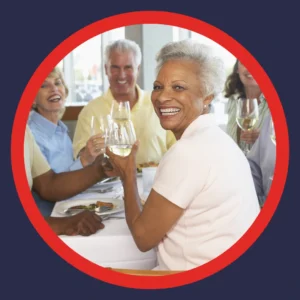 Older friends toast each other at a restaurant.