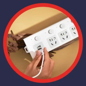 A hand plugs a cable into a plug.