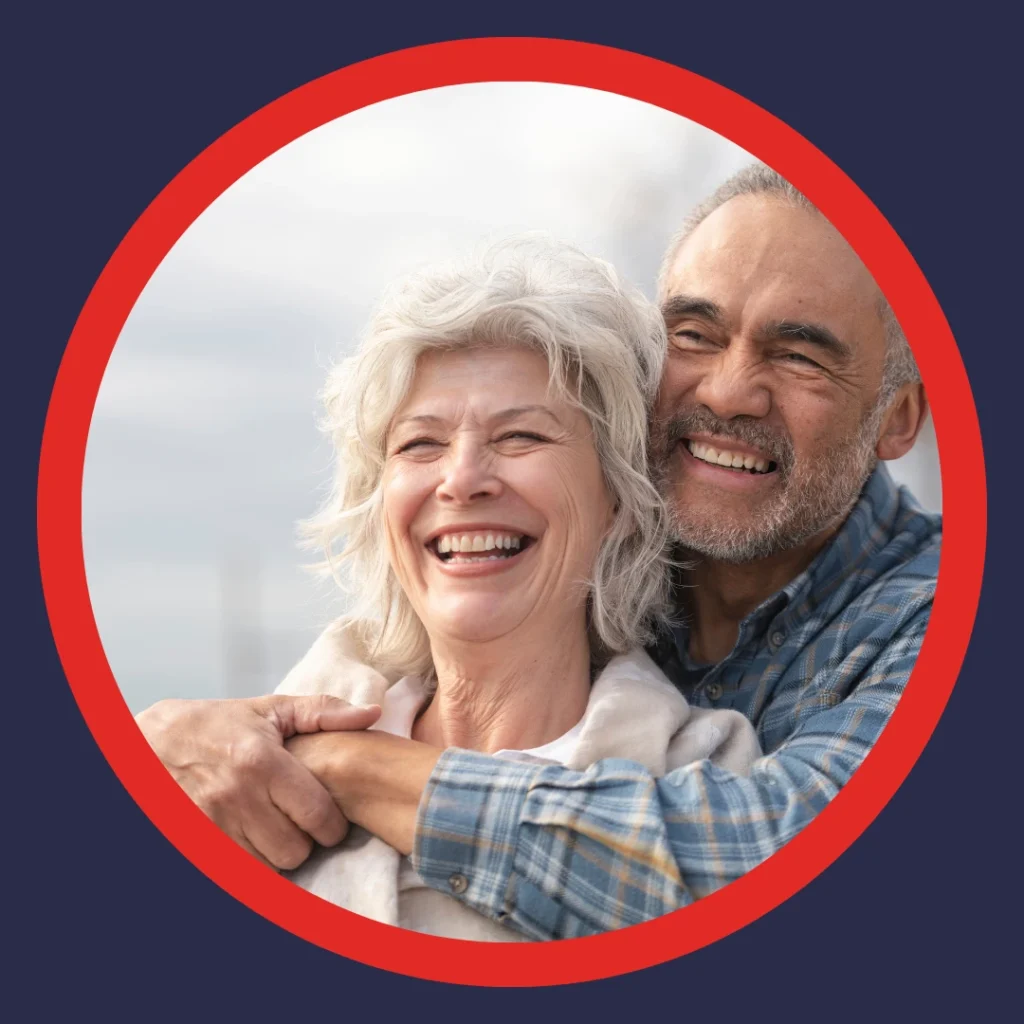 An older couple smiles and cuddles.