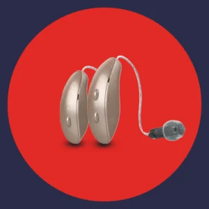 A pair of Starkey Edge AI hearing aids rest on a red background. 