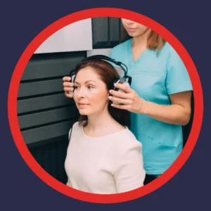 An audiologist puts headphones onto a patient. 