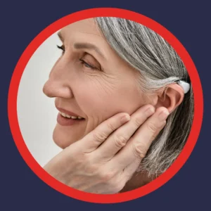 A woman holds an ear with a hearing aid. 