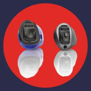 A pair of Phonak Virto hearing aids sit on a red background. 