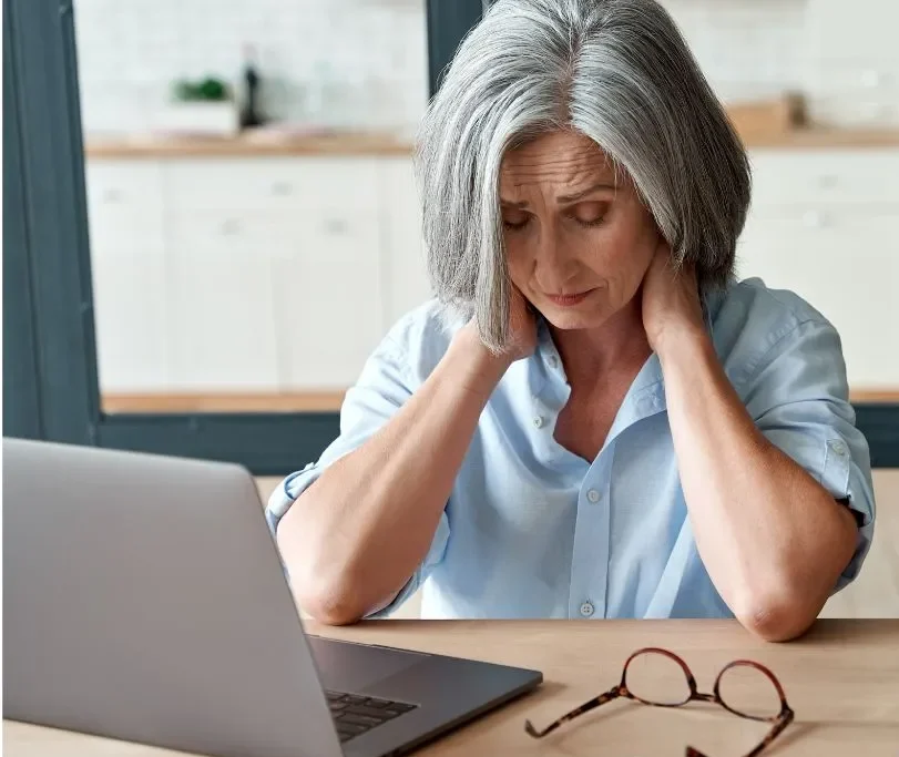 A woman looks stressed as she sits in front of her laptop.